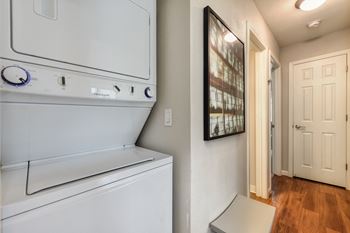 Washer Dryer with Wood Inspired Floor, White Doors, Ceiling Lights at Addison Ranch Apartments, Petaluma, CA
